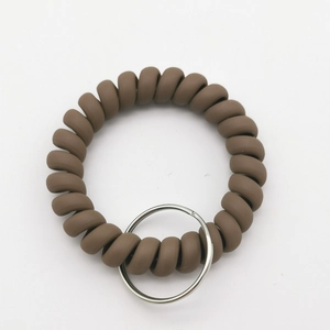 Close-up of matte dark brown spiral telephone wire wristband with silver metal keyring