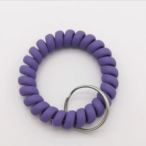 Macro detail of purple spiral wristband keyring with polished silver metal ring