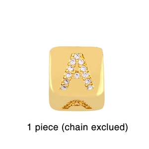 Detailed close-up of a square gold pendant with letter A inlaid with white zircons