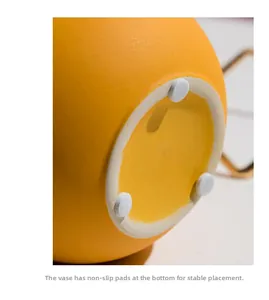 Detail view of yellow ceramic vase base with non-slip pads for stable placement