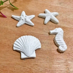 Detailed close-up of resin starfish and seahorse ornaments on a rustic wooden surface