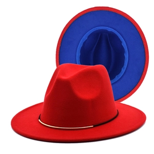 Close-up of dual-tone fedora hat with red felt exterior and blue lining with gold buckle
