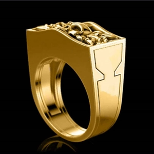 Macro shot of gold skull ring with detailed relief on black reflective surface