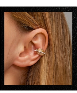 Close-up of gold leaf-style layered ear cuff with white rhinestones on model's ear