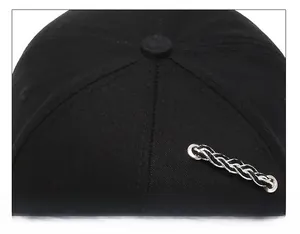 Detailed close-up of reinforced stitching and metal eyelets on a black cotton baseball cap