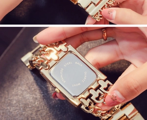 Detailed close-up of the stainless steel back and quartz movement of the gold chain watch