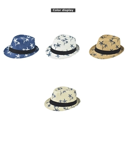 Detail display of four linen summer hats featuring dark palm tree patterns and black bands
