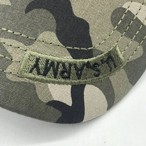 Détail macro de la broderie U.S. ARMY sur le tissu camouflage de la casquette militaire