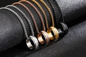 Detail view of four spinning ring pendants in silver, rose gold, gold and black finish