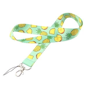 Detail of mint green fabric lanyard featuring yellow pineapple patterns and metal clasp