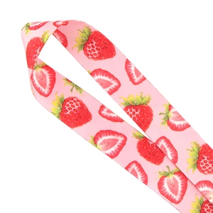 Close-up of pink fabric phone lanyard featuring vibrant strawberry patterns on a white background