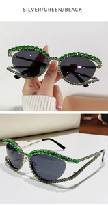 Dettaglio di occhiali da sole cat-eye di lusso con strass verdi e montatura argento