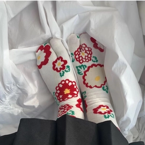Detail of Japanese tabi socks with red flower patterns on white cotton fabric