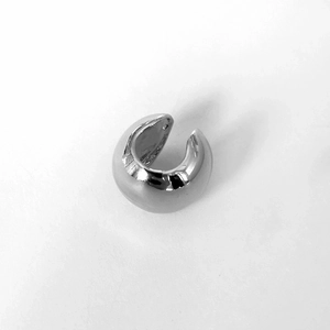 Minimalist silver geometric ball ear cuff with polished metallic finish on white background