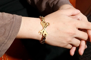 Gros plan détaillé d'un bracelet doré en forme de clé à molette pour homme