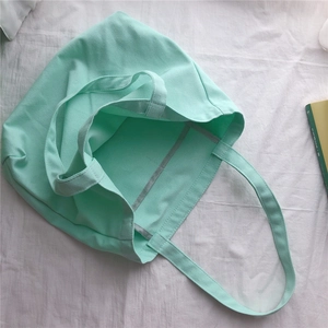 Détail de l'intérieur du sac en toile vert menthe avec bordures de couture grises