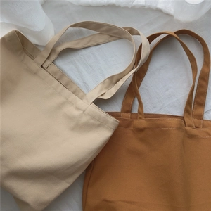 Vue à plat de sacs fourre-tout minimalistes en toile beige et marron avec surpiqûres