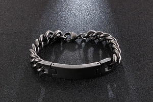Close-up of men's matte black titanium steel bracelet with flat rectangular ID plate