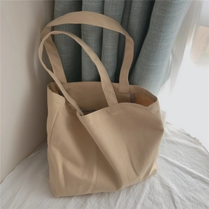 Texture détaillée du sac fourre-tout en toile beige sous une lumière naturelle douce