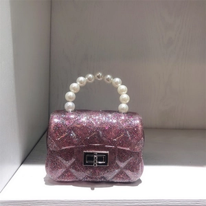 Close-up of pink glitter jelly bag with quilted pattern and elegant pearl handle