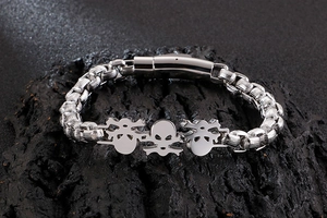 Close-up of vintage punk skull stainless steel bracelet on a dark textured stone background
