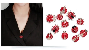 Detail of ladybug brooches with red enamel, gold finish, and sparkling rhinestones