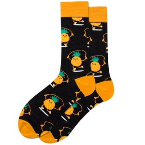 Close-up of black cotton socks featuring orange accents and funny cartoon pineapple patterns