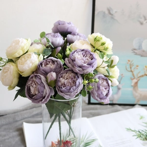 Detailed view of purple and cream artificial peony bouquet in a clear glass vase