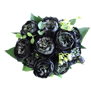 Close-up of black artificial roses and peonies with green leaves and silk petals
