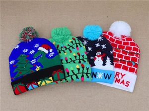 Flat lay of colorful LED knitted Christmas hats with dinosaur and snowman patterns