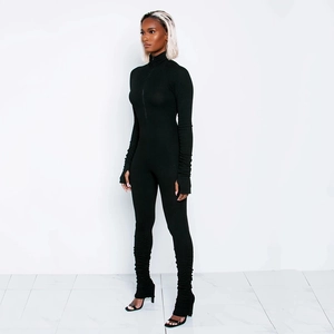 Detail of black ribbed long sleeve jumpsuit featuring mock neck and stacked cuffs