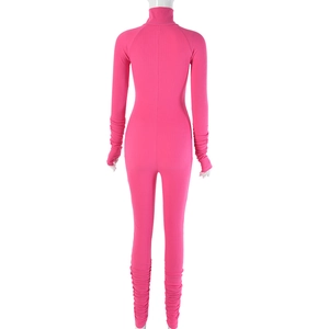 Rear view of pink ribbed knit jumpsuit showing high neck and stacked ruched cuffs