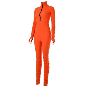 Detail view of orange slim fit bodysuit with front black zipper and ruched sleeves