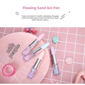 Detail view of liquid glitter floating inside lipstick shaped pens on a pink desk