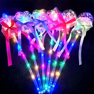 Close-up of heart-shaped glowing fairy wands with LED lights and colorful sequins