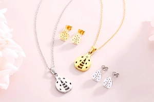 Detailed set of gold and silver hollow leaf jewelry with inset diamonds on pink background