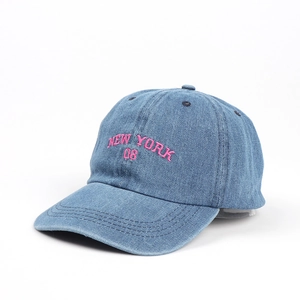 Detail der pinken NEW YORK Stickerei auf blauer gewaschener Denim-Baseballkappe mit Textur