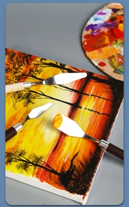 Artistic detail of stainless steel palette knives on sunset oil painting background