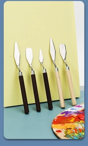 Artistic set of five diverse stainless steel palette knives with wooden handles