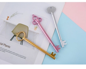 Macro detail of retro key-shaped gel pens in gold, silver, and pink metallic finish