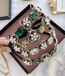 Détail de serre-têtes baroques avec gemmes émeraude, perles et ornements en cristal