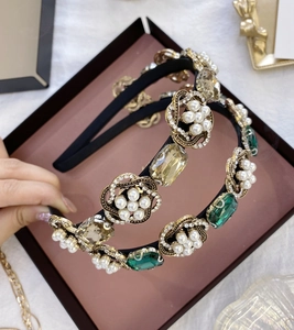 Détail du serre-tête baroque avec cristaux émeraude, perles et motif floral vintage