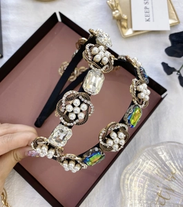 Vue détaillée du serre-tête baroque avec perles et strass sur base dorée mate