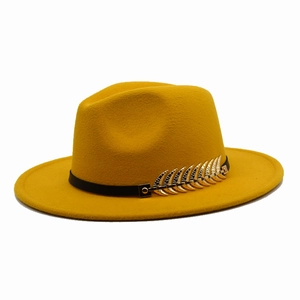 Detail of a ginger fedora hat made of felt wool with a black band and gold feather pin