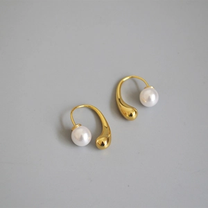 Detail of gold-plated water drop earrings with white round pearls in French style