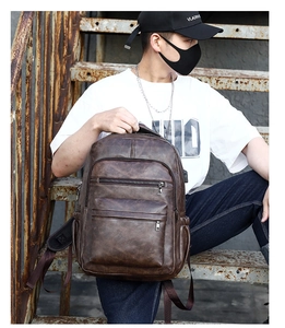 Macro shot of dark brown vintage PU leather backpack with multi-layer zipper pockets