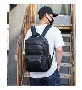 Modern black PU leather backpack for men featuring side USB charging port detail