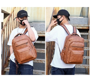 Detail of vintage brown PU leather backpack featuring stylish metal zippers and large pockets
