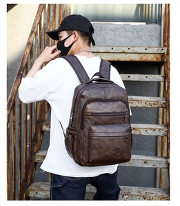 Detail shot of a dark brown vintage PU leather backpack worn on a casual travel trip
