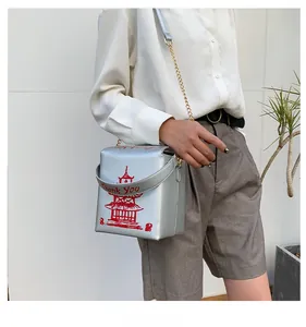 Detail of silver square crossbody bag featuring red pagoda print and chain strap